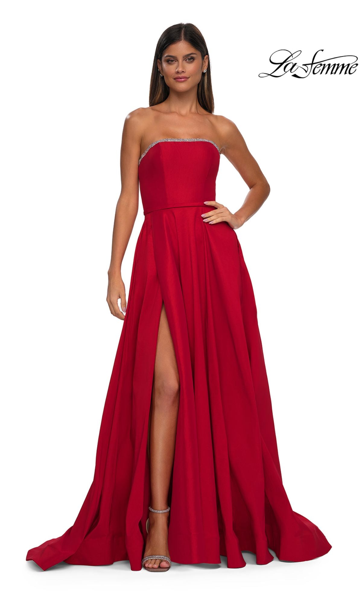 A woman in the La Femme 33063 strapless long A-line prom dress with rhinestone beading and a high slit stands confidently, showcasing the fitted bodice, full skirt, and her high-heeled sandals.